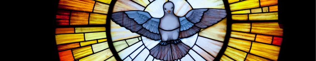 A thin banner style photo of a stained glass window; a dove is flying in the midst of a sunburst of yellow, orange, and red. 