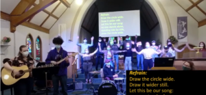 A group of youth leading a song in worship