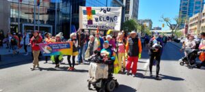 People carrying "You Belong" St. Mary's Road Banner in parade