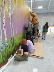 5 youth working on mural