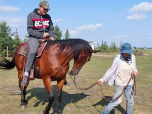 Youth on horse, being led by someone holding halter.