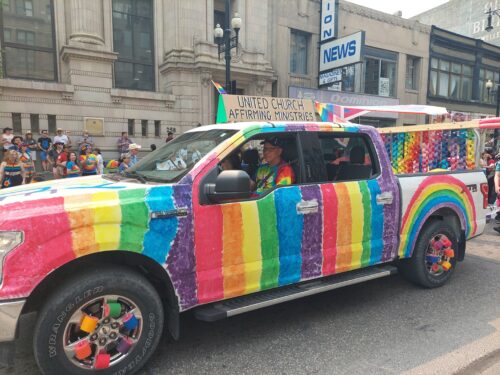 A photo of a colorful truck in a pride parade.