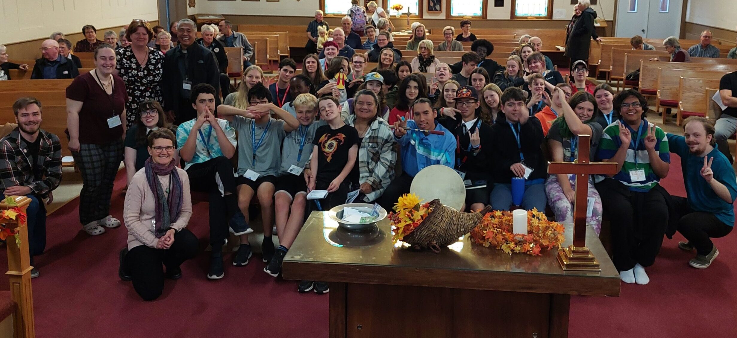 A group of youth from the last youth retreat sitting in church pews